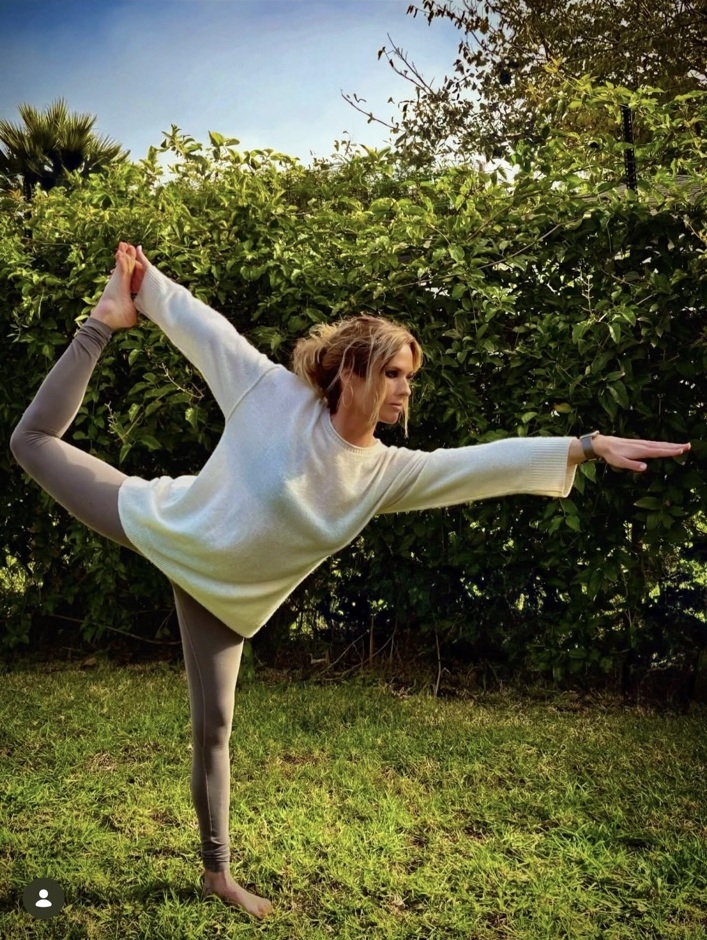 Katie Elmore practicing yoga in a sunlit garden